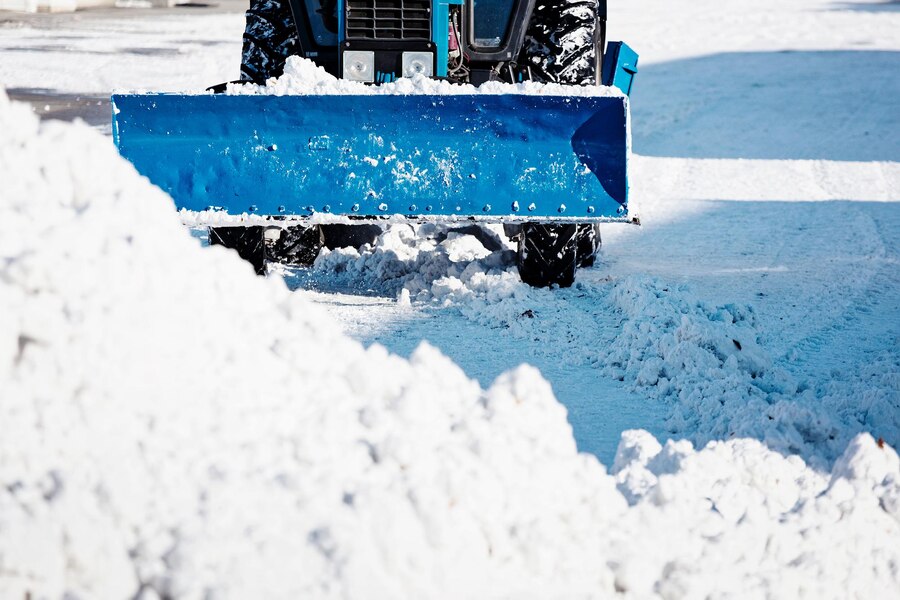 blue-tractor-with-shovel-cleans-streets-snow-sunny-winter-day_230115-2815