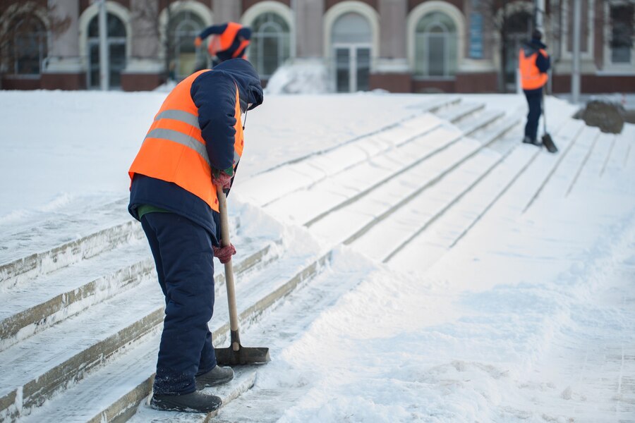 workers-sweep-snow-from-road-winter-cleaning-road-from-snow-storm_199620-6501